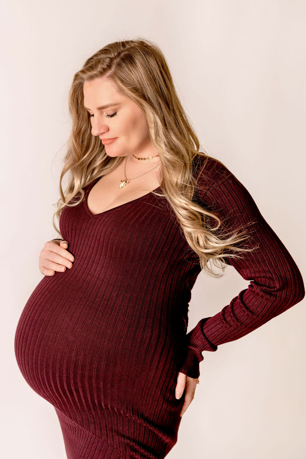 mom to be in maroon dress holding the bump Spas in Fairfield County
