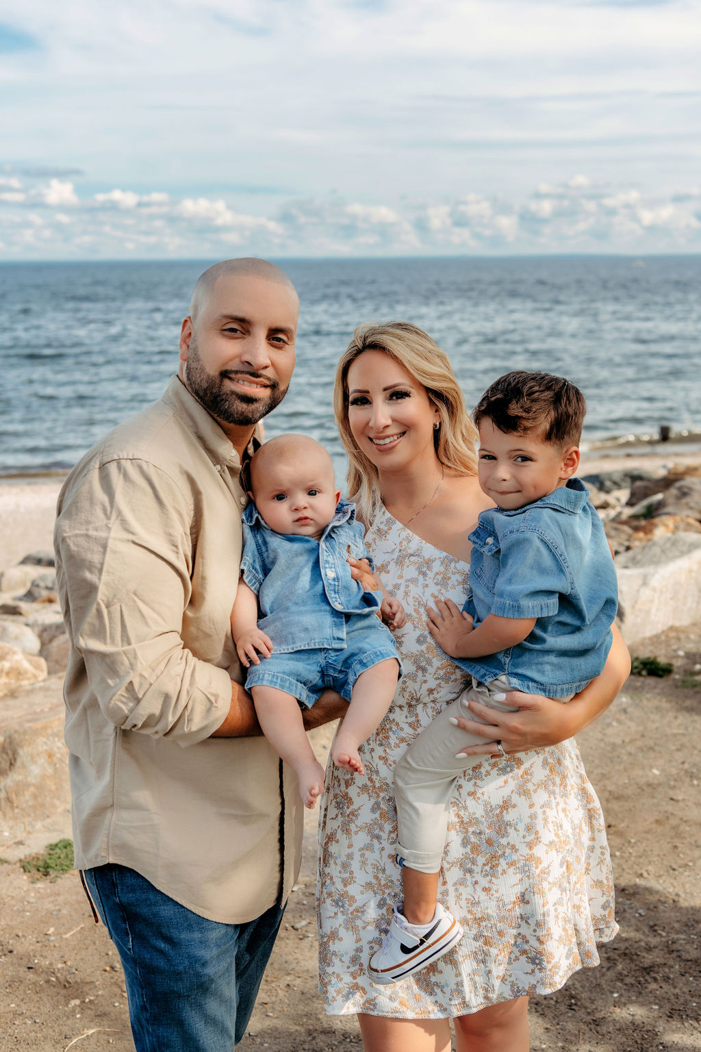 family of four at the beach dressed in blues and neutrals