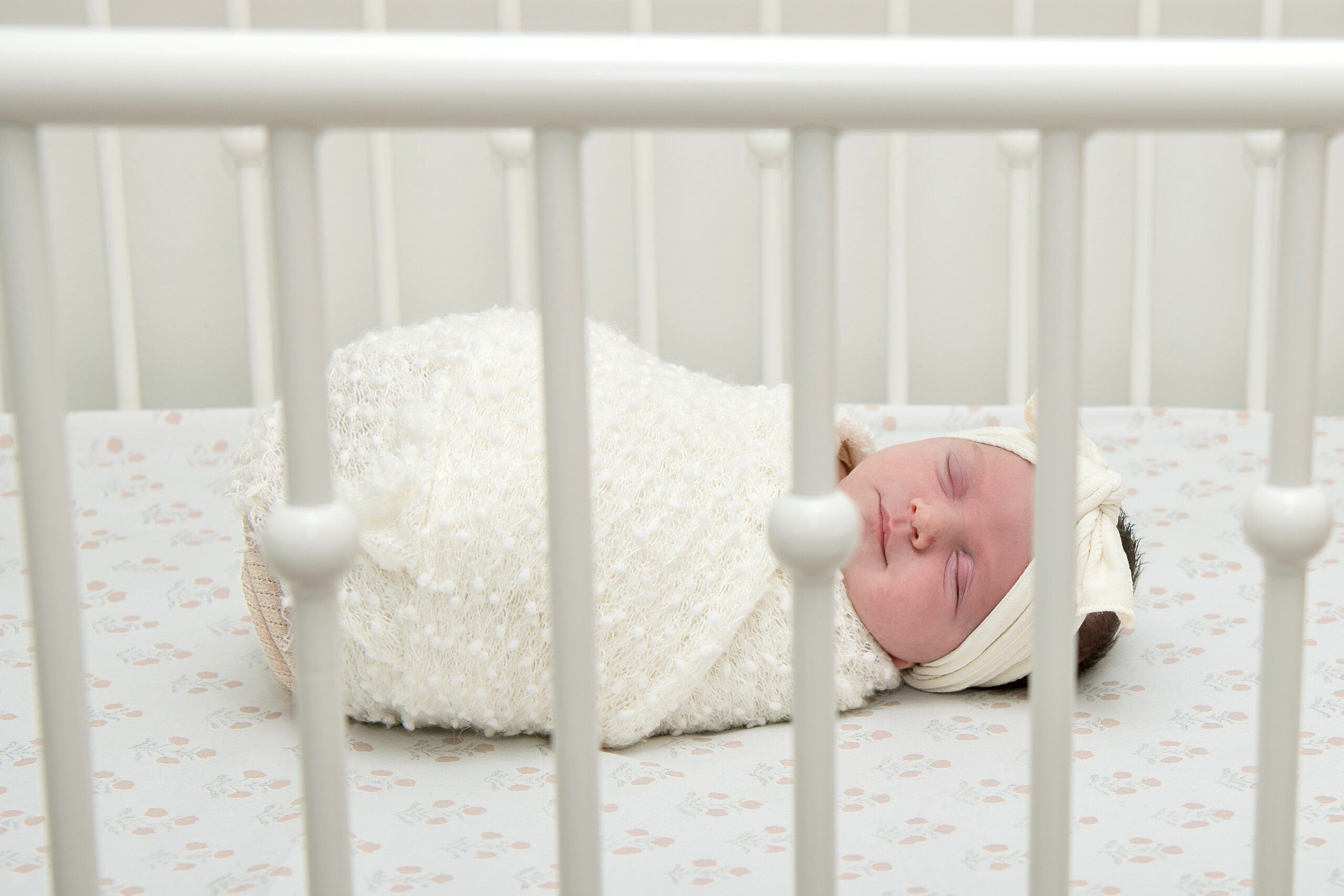 newborn baby girl sleeping peacefully in her crib.
