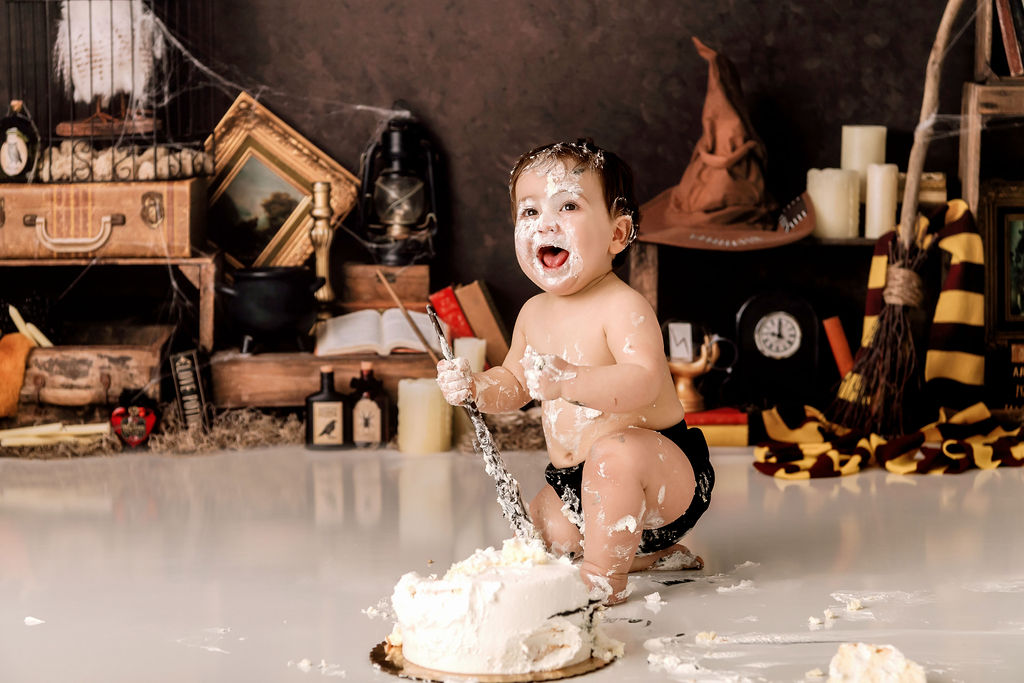A baby cheers while covered in cake in a studio after some exciting baby classes in Stamford, CT